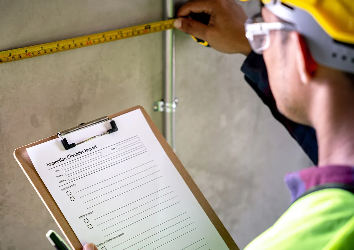 Técnico electricista con casco revisando un parte de trabajo